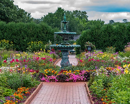 water fountain in midst of landscaped flower gardens