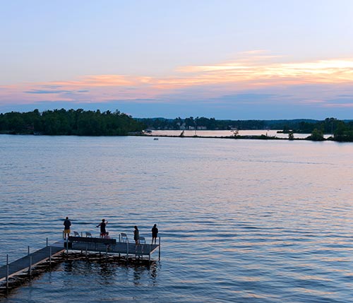 view of dock on lake at sunset