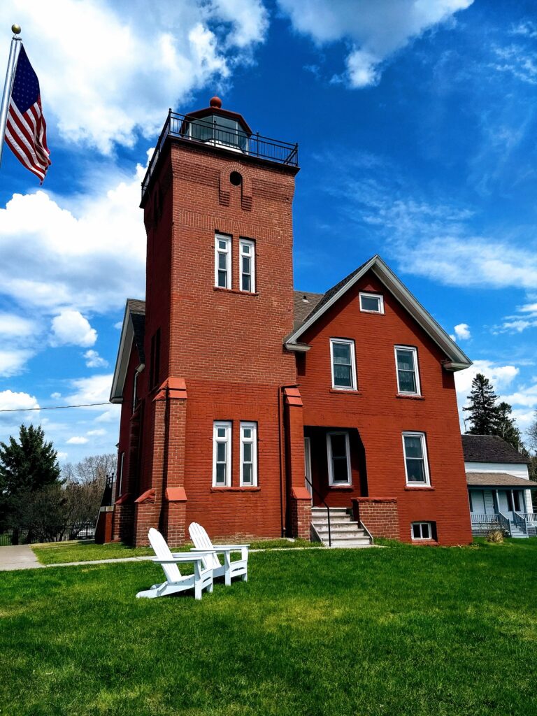 lighhouse-bed-breakfast-blue-skies-white-chairs-red-brick-sides
